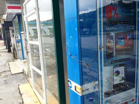 Lợi dụng bão, cạy phá cây ATM lấy tiền - 2 Các cây ATM ở khu vực gần đó hiện đã tạm ngừng hoạt động và chằng dây thép bảo vệ bên ngoài.