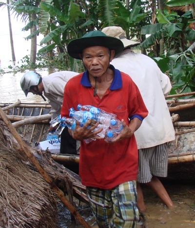 Cụ ông Võ Văn Mười (68 tuổi, thôn Phước Thịnh) hồ hởi mang những chai nước quý giá vừa được cứu trợ