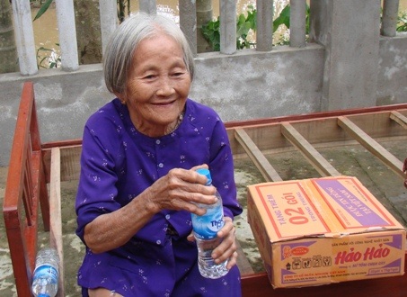 Cụ ông Võ Văn Mười (68 tuổi, thôn Phước Thịnh) hồ hởi mang những chai nước quý giá vừa được cứu trợ