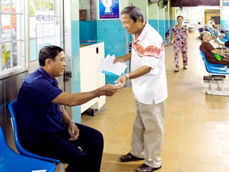 Nhân viên bệnh viện cấp số thứ tự cho bệnh nhân.