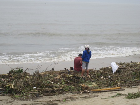 Rác ngập bãi biển, người dân tranh thủ thu nhặt củi, gỗ