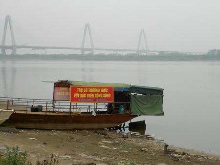 Chiếc thuyền dưới chân cầu Nhật Tân là nơi anh Dũng trực hàng ngày để phát hiện xác chết trôi sông