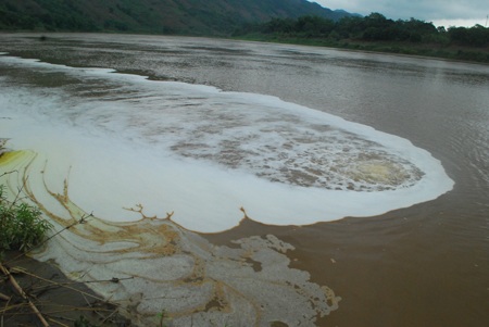 Cận cảnh họng nước thải đang phụt dòng nước có bọt màu trắng ra sông Hồng.