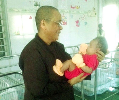 Sư cô nâng niu trẻ sơ sinh bị bỏ rơi.