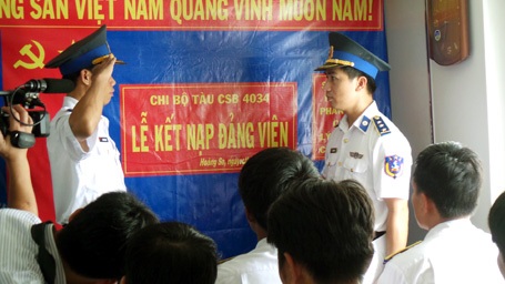 Hai đảng viên mới đọc lời tuyên thệ, xin thề trước cờ Đảng.