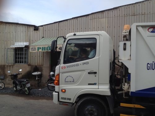 Xem xét kỷ luật tài xế cho bé trai 5 tuổi điều khiển xe chở rác - 1 Cháu bé 5 tuổi ngồi ở vị trị lái chính, sau lưng là ông nội
cũng là tài xế xe rác