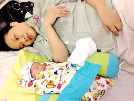 Bà Thái Thị Tuyến - mẹ trung úy Nguyễn Văn Hưng hạnh phúc bế cháu nội trên tay.