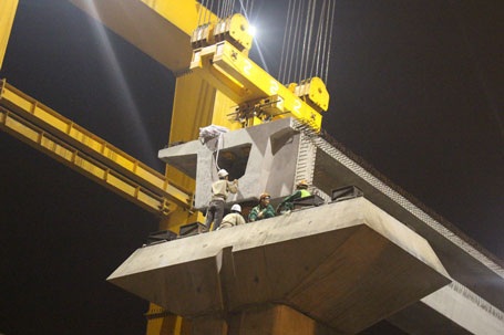 Các công nhân đang trực tiếp điều chỉnh dây cẩu sao cho khớp với khối bê tông