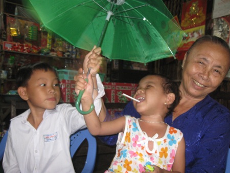 Cháu Ngân hạnh phúc trong vòng tay bà nội, chơi đùa vui vẻ với anh trai.