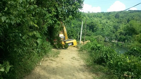 Lực lượng công an bảo vệ hiện trường chiếc máy san gạt bị trúng mìn phục vụ công tác điều tra.