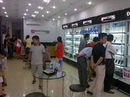 Thị trường iPhone trầm lắng - 1 Khách xem điện thoại tại showroom Nhật Cường.
