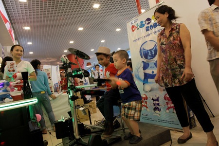 Một em nhỏ chơi trống cho robo nhảy