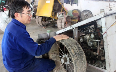 Ông Trương Minh Hải bên chiếc máy gặt lúa chế tạo từ đồ phế thải.