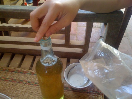 Tinh vi mật ong "xịn" từ.... vỏ cây, đường và phèn chua - 1 Ông H cho một ít sáp ong vào chai cho giống mật ong thật.