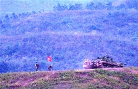 Xem bộ đội hiệp đồng đánh địch đổ bộ đường không - 7 Quân ta cắm cờ chiến thắng trên một điểm cao, sau khi tiêu diệt địch ở đây.