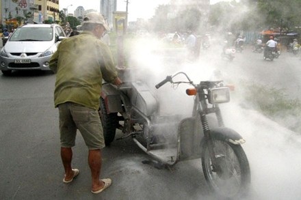 Xe ba gác tự chế bốc cháy ngùn ngụt trên phố - 1 Chiếc xe ba gác tự chế được người dân trên đường dùng bình chữa cháy dập lửa.