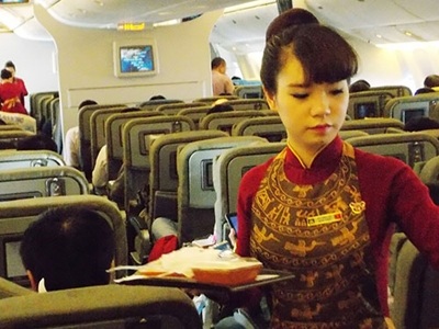 Tiếp viên của hãng VNA phục vụ hành khách trên một chuyến bay.