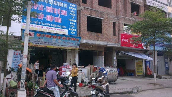 Mặt tiền của những căn biệt thự thô được mặc áo bằng biển quảng cáo.