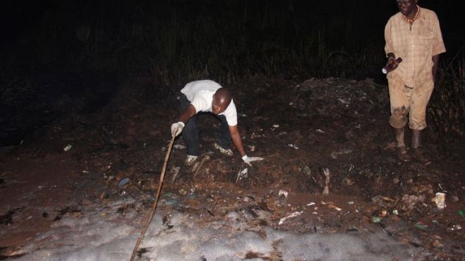 Xe téc chở dầu bất ngờ phát nổ, 31 người "hôi của" chết cháy - 1 Nhân viên cứu hộ đang kéo thi thể của nạn nhân ra