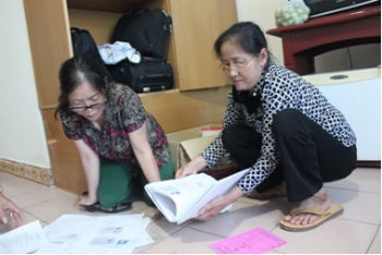 Bà Xoan (mang kính bên phải) với những tài liệu tố cáo ông Quý.