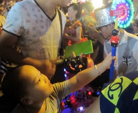 Gangnam style “phủ sóng” đồ chơi trung thu Việt - 1 Một cậu bé mê tít món đồ chơi sặc sỡ “made in China”.