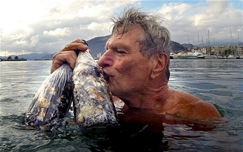 Ông Pierluigi Lugano nâng niu hai chai rượu được lấy từ đáy biển.