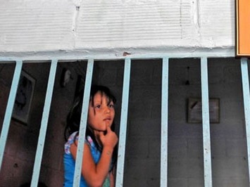 Một bé gái đứng sau khung cửa ở Medellin