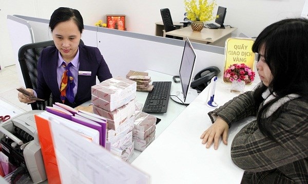 Nhiều nhân viên ngân hàng “chật vật” khi Tết đến - 1 Áp lực đối với nhân viên ngân hàng ngày càng cao nhưng thu nhập lại bị giảm. (Nguồn: TTXVN).