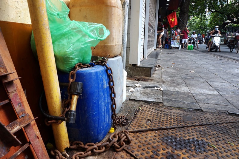 Chiếc can nhựa của một cửa hàng bán đồ ăn sáng trên vỉa hè Hàng Gà được khóa bằng khóa chữ U chuyên dùng để khóa xe máy.
