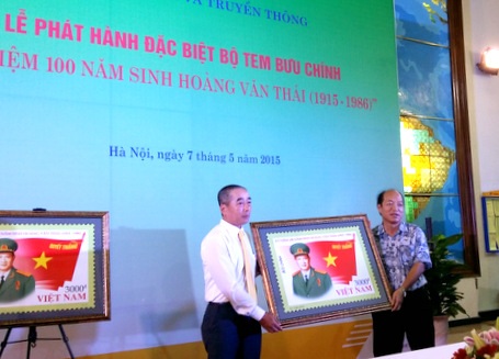 Phát hành bộ tem “Kỷ niệm 100 năm ngày sinh Hoàng Văn Thái” - 1 Đại diện Ban tổ chức trao tặng ảnh bộ tem tới gia đình Đại tướng Hoàng Văn Thái (bên trái)