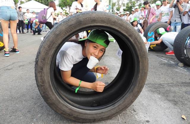 Một nữ sinh thử sức trong trò chơi đưa ly nước về đích bằng miệng