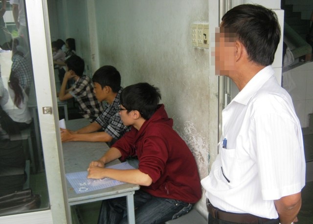 Phụ huynh chăm thí sinh 18 tuổi như… em bé - 1 Bố mẹ dắt con vào tận phòng thi, nhìn con ngồi vào chỗ... vẫn chưa yên tâm quay ra