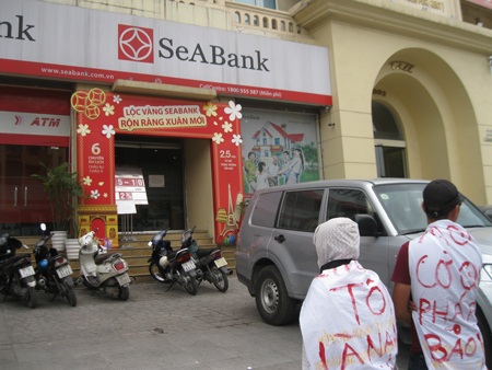 Mặc đồ kỳ quái, tụ tập trước trụ sở SeABank đòi trả sổ đỏ thế chấp - 1 Người dân từ các tỉnh tụ tập trước trụ sở chi nhánh ngân hàng SeAbank sáng ngày 23/4
