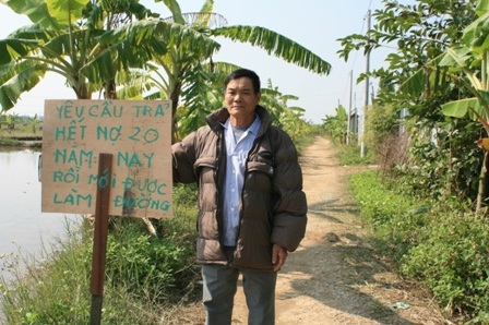 Dân dựng biển giữa đường đòi xã trả món nợ... 20 năm - 1 Ông Toan dựng biển đòi nợ tại con đường mà 20 trước ông đã phải thay mặt xã đi vay thóc làm.