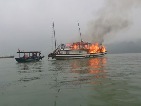 Tàu du lịch bốc cháy trên vịnh Hạ Long - 1 Các tàu gần đó đang phun nước dập lửa cho tàu du lịch QN3736bị cháy trên vịnh