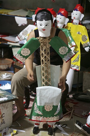 Một người thợ đang lắp ráp một hình nhân.