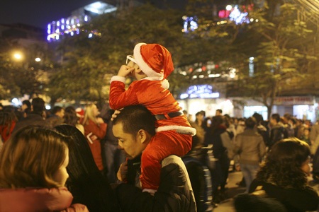 Đêm Noel ở Nhà thờ lớn - 14 Một Ông già Noel nhí ngắm nhà thờ trên vai bố.
