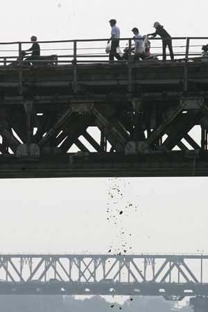 Tro bụi được người dân đứng trên cầu Long Biên thả xuống mù mịt.