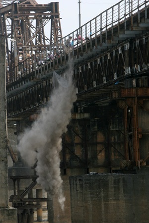 Tro bụi được người dân đứng trên cầu Long Biên thả xuống mù mịt.