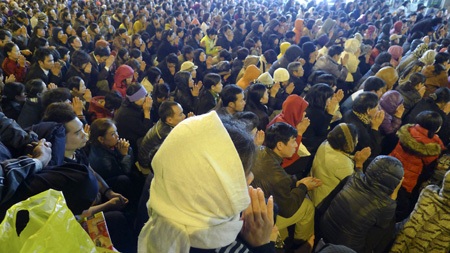 Hà Nội: Biển người trong lễ cầu an - 16 Những người ngồi làm lễ cầu an trong tiếng xe cộ ầm ì bên cạnh.