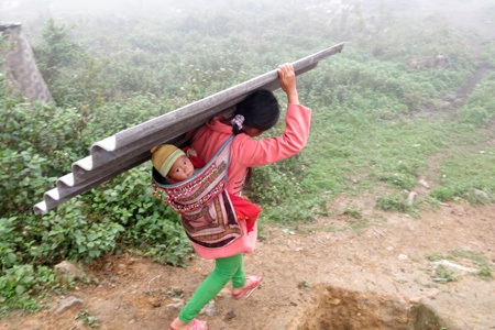 Hai mẹ con phải các tấm lợp về vì nhà neo người.