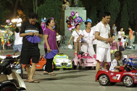 Hà Nội đêm hóng gió - 3 Các bậc cha mẹ cho con ra chơi ở chân tượng đài Lê - Nin đều cầm quạt nan trên tay để quạt cho trẻ.
