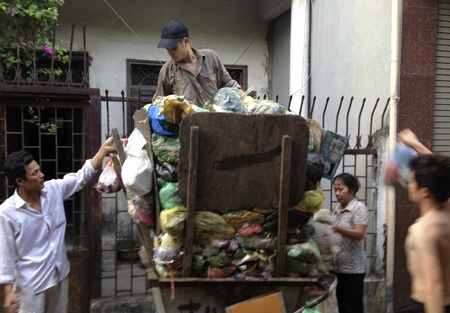 Những xe rác tự chế “đặc biệt” ở thủ đô - 4 Những người vứt rác khi xe đã đầy đều phải ở tư thế ngửa mặt hứng bụi rác.