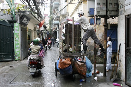 Những xe rác tự chế “đặc biệt” ở thủ đô - 5 Người công nhân đang sắp xếp để chở nhiều rác hơn.