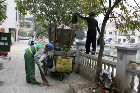 Những xe rác tự chế “đặc biệt” ở thủ đô - 6 Xe rác quá cao, người dân phải leo bậc để vứt rác.