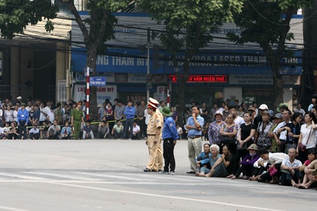 Các sinh viên tình nguyện đứng thành hàng bảo đảm giao thông trên nhiều tuyến phố.