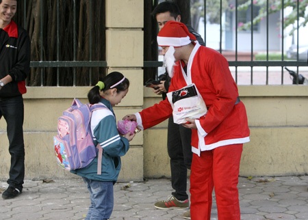 Một Hà Nội rất khác trước đêm Noel - 5 Một em nhỏ ngẫu nhiên được tặng quà từ Ông già Noel khi trên đường đi học về.