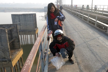 Các túi tro và cá của người dân được họ vui vẻ nhận, sau đó phân loại.