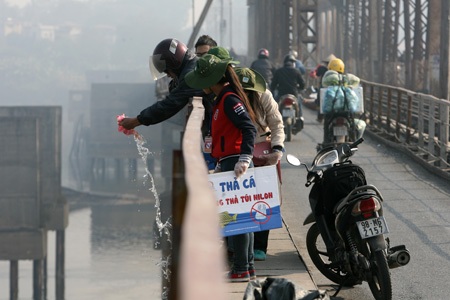 Nhiều người muốn tự tay thả cá, nhóm sinh viên lại đứng chờ để xin túi nilon, rồi cảm ơn lễ phép.