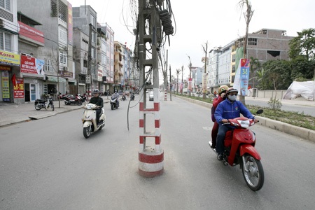 Những cây cột điện “quái dị” trên con đường mới - 11 Mớ dây lủng lẳng từ các cây cột xà xuống đường.